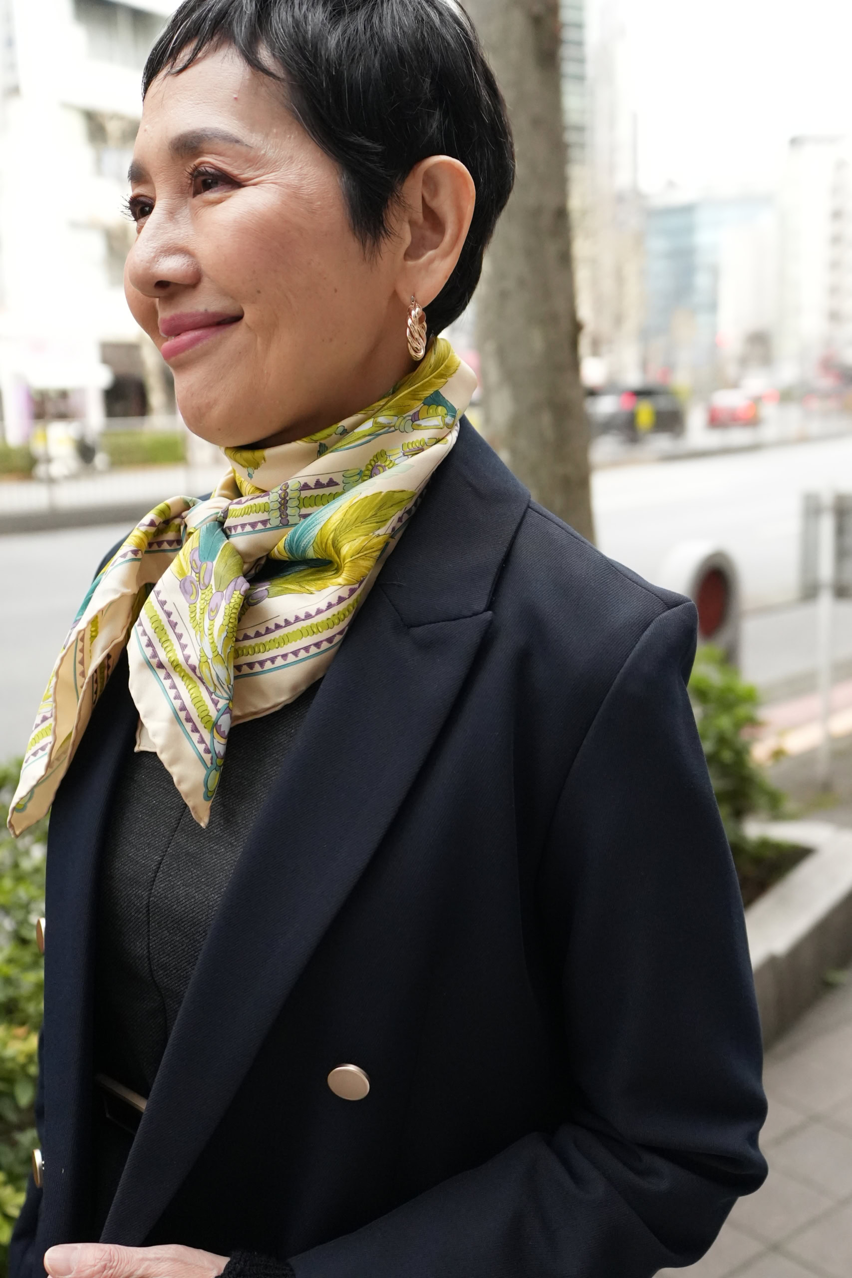 「ネイビーにグレーなどダークカラーがメインなので首元は春らしい鮮やかなカラーのスカーフを。顔まわりが品よく華やかにキマる上に、視線を首元に集めることですらりとしたシルエットを強調することもできます」