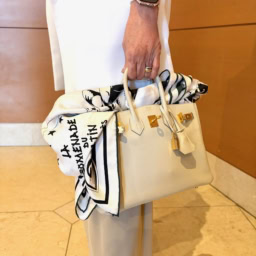 会場内での寒さ対策を兼ねて、「エルメス」のスカーフは夏の必須アイテム。それを「エルメス」のバッグにふわっと乗せて個性をプラス。「モノトーンのプリントがコーデのアクセントにもなるんです！」