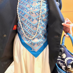 「エルメス」のスカーフをビスチェ風に巻いて、インナーに使うという大胆なアイデアが、「ドゥーズイエムクラス」の定番紺ブレを一気に個性的で華やかな印象に。 「スカーフの鮮やかなブルーカラーが、紺ブレの色に合っていると感じて、クルッと巻いてみました。クリップ同様、ちょっと遊び心で楽しんでいます」