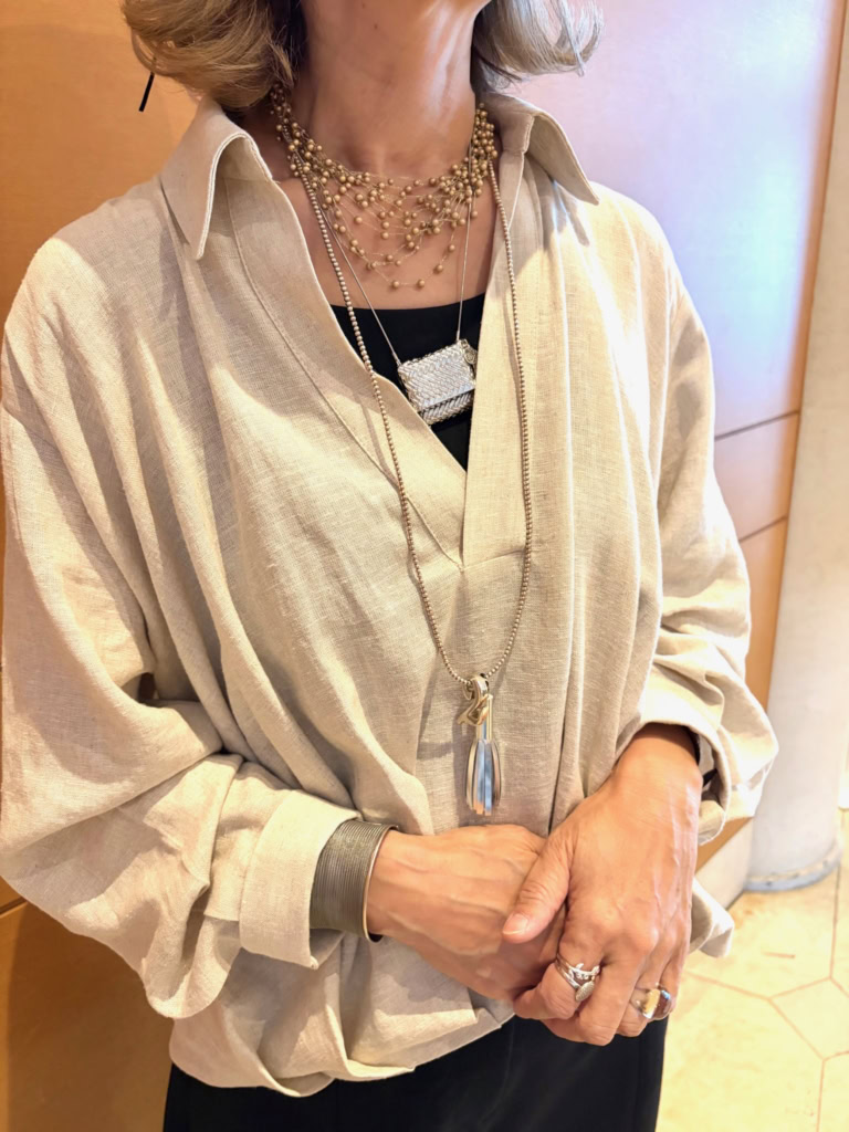 「MiRie」のネックレスとレザーリングで首元・手元にさりげないアクセントを。「首元には、3つの長さをレイヤードすることで、立体感を出しています。ここはあえてシルバーとゴールドのミックス。バッグ型のネックレスは『ココシンクスタイル』。中にメッセージを入れてお守りのように持ち歩くこともできるんですよ」