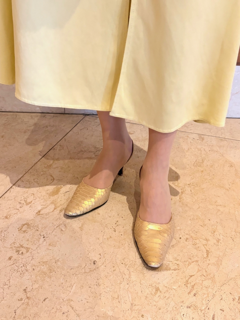 「Stephane Kelian」のゴールドパンプスが、イエローワンピースと相性抜群。 「足元は、地味になりすぎないよう、ゴールドで明るく。上品な華やかさをプラスし、全体のエレガントなムードを完成させる優秀パンプス。ヒールもそこまで高くないので、歩きやすいんです」