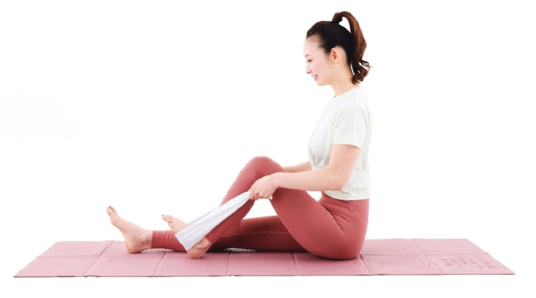 【1】床に座り、片足の裏にタオルをかける。