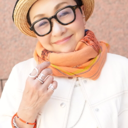 「アクセサリーやストールなどの小物をシルバー×オレンジに。フレッシュで夏っぽい印象に仕上がりました。コーデ全体がホワイトベースなので、黒縁メガネが際立ち顔まわりが引き締まって見えます」
