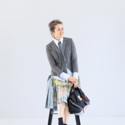 ネクタイ¥42,900、ネクタイピン¥70,400、ジャケット¥281,600、シャツ¥138,600、スカート¥493,900、バッグ¥753,500、犬のチャーム各¥64,900、シューズ 参考商品／すべてトム ブラウン（トム ブラウン ジャパン）、ピアス（右耳）¥121,000、重ねたリング（指先から）¥162,800、¥200,200 ／すべてヒロタカ（ヒロタカ表参道ヒルズ）、ソックス／スタイリスト私物