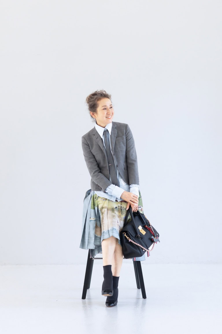 ネクタイ¥42,900、ネクタイピン¥70,400、ジャケット¥281,600、シャツ¥138,600、スカート¥493,900、バッグ¥753,500、犬のチャーム各¥64,900、シューズ 参考商品/すべてトム ブラウン(トム ブラウン ジャパン)、ピアス(右耳)¥121,000、重ねたリング(指先から)¥162,800、¥200,200 /すべてヒロタカ(ヒロタカ表参道ヒルズ)、ソックス/スタイリスト私物