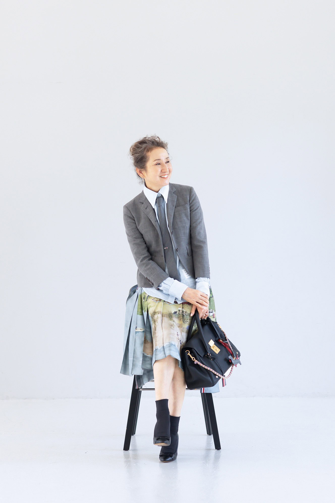 ネクタイ¥42,900、ネクタイピン¥70,400、ジャケット¥281,600、シャツ¥138,600、スカート¥493,900、バッグ¥753,500、犬のチャーム各¥64,900、シューズ 参考商品／すべてトム ブラウン（トム ブラウン ジャパン）、ピアス（右耳）¥121,000、重ねたリング（指先から）¥162,800、¥200,200 ／すべてヒロタカ（ヒロタカ表参道ヒルズ）、ソックス／スタイリスト私物