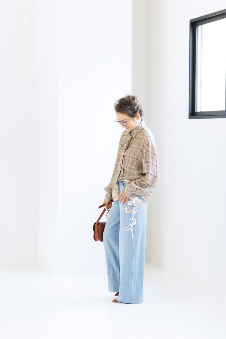 ネクタイつきブラウス¥159,500、デニムパンツ¥128,700/ともにエルマンノ フィレンツェ(ウールン商会)、メガネ¥49,500/アイヴァン(アイヴァン 東京ギャラリー)、ピアス¥286,000、薬指に重ねたリング(指先から)¥253,000、¥66,000、人さし指につけたリング¥572,000/すべてシンティランテ(イセタンサローネ東京ミッドタウン)、バッグ¥172,700/ピエール アルディ(ピエール アルディ 東京)、シューズ¥147,400/マローン・スリアーズ(メゾン・ディセット)