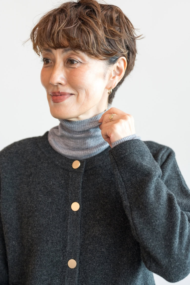 明るいグレーのニットをレイヤードして顔周り華やかに