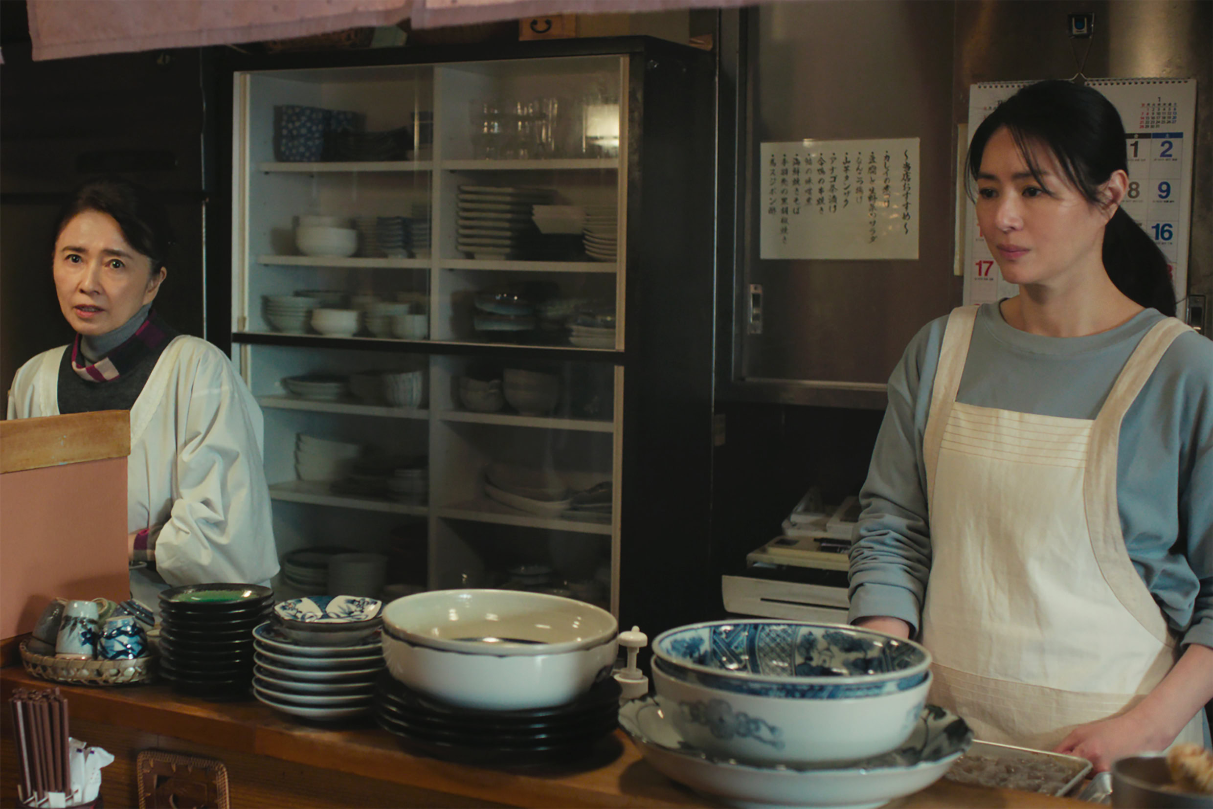 映画『白鳥とコウモリ』より小料理屋あすなろを営む浅羽洋子(風吹ジュン)と織恵(井川遥)