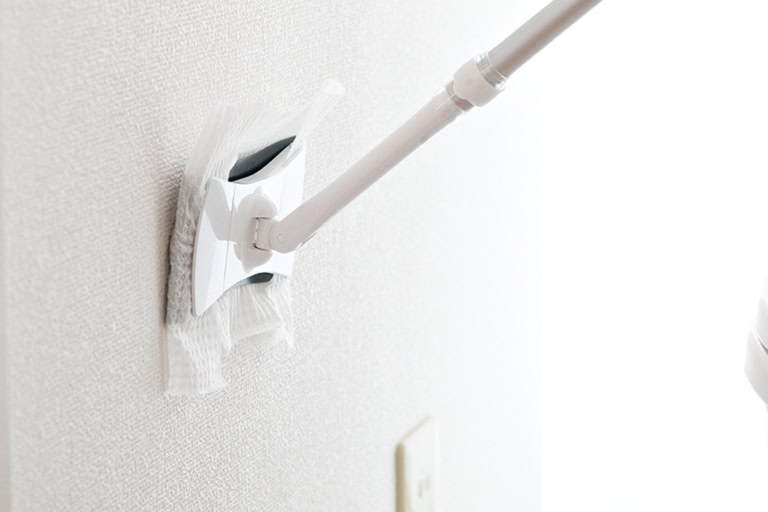 【1】壁と床はトイレ用掃除シートで、尿や水のハネ、ホコリなどの汚れを拭き取る。掃除シートをセットしたトイレ用のミニフロアワイパーがあると便利。作業はまず壁を上から下に拭き、次に床を拭く。
