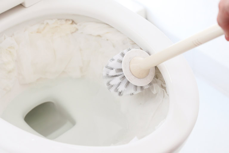 【2】ペーパーの上からトイレブラシで汚れをこすり落とし、水たまりにペーパーを入れてから水を流す。